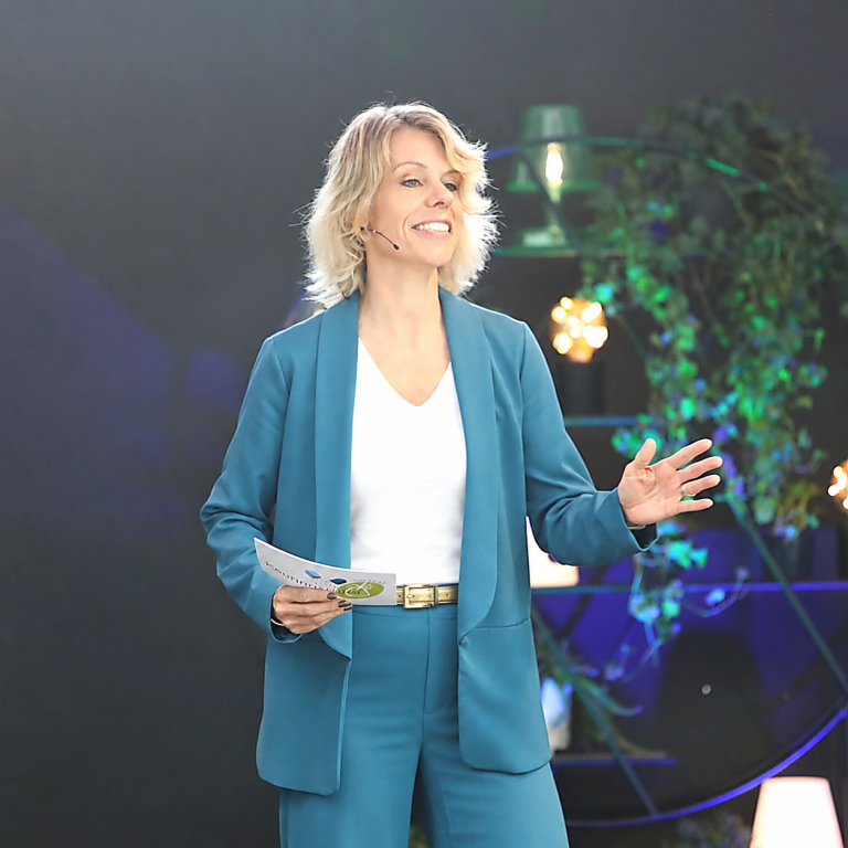 Suzan Tuinier als dagvoorzitter op het podium